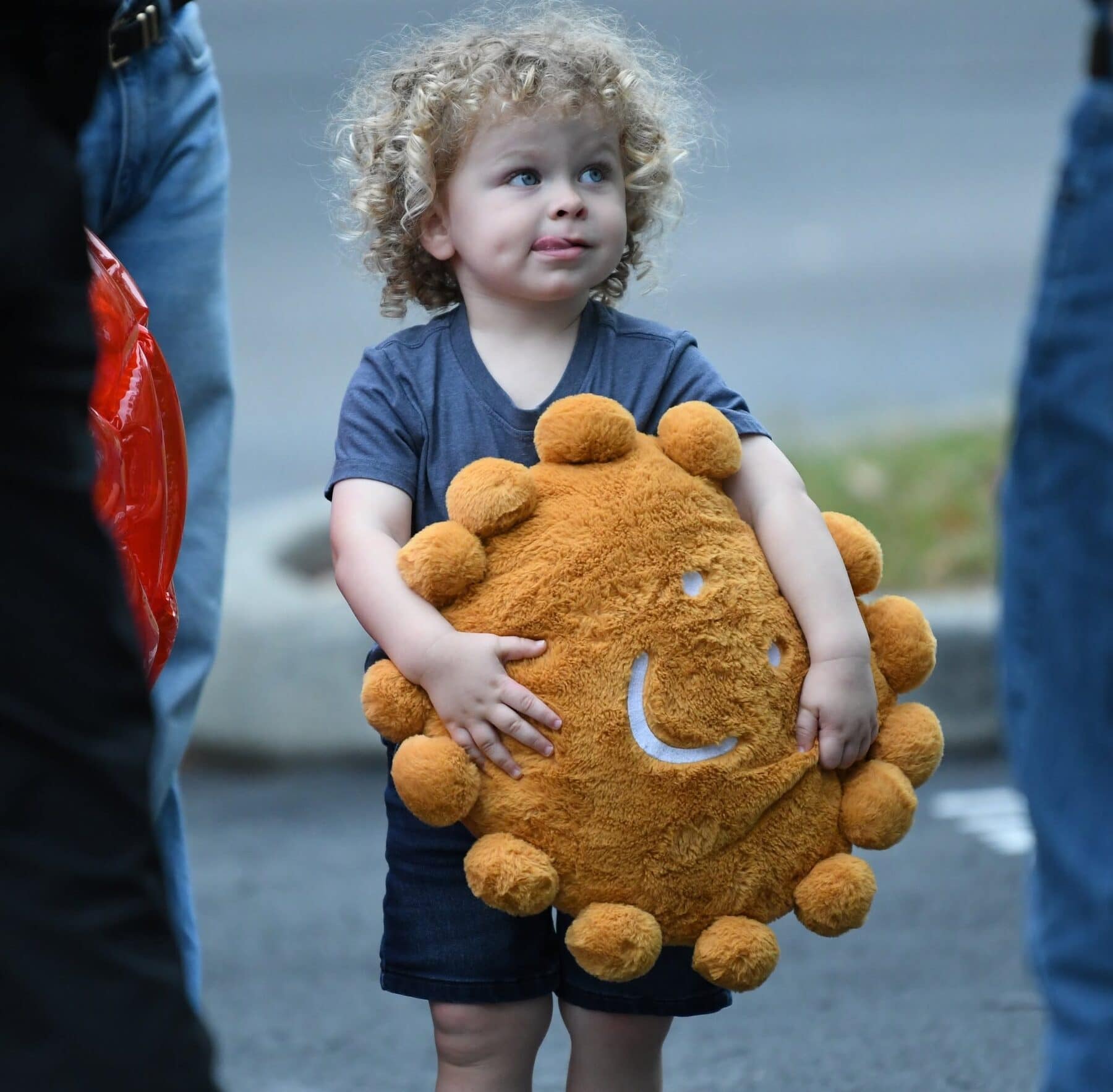 A young child holding a plush sun.