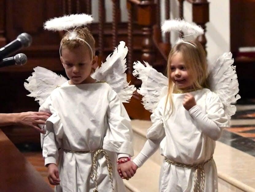 Two young students dressed as angels during chapel.