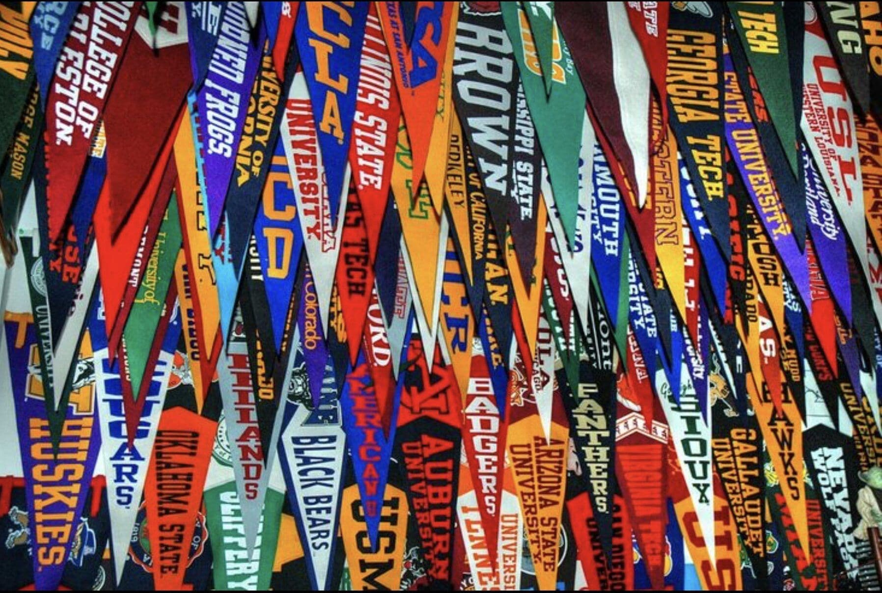 A dense display of college and university pennants representing where Saint Stephen's graduates have matriculated.